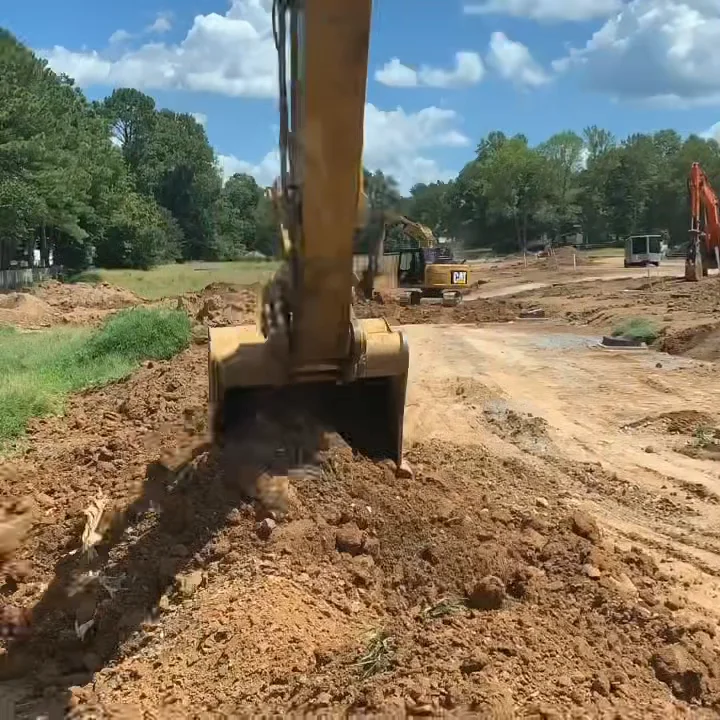 Excavator bucket working in dug earth at close range.